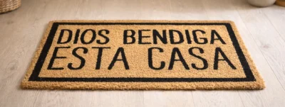 Felpudo cristiano con el mensaje “Dios bendiga esta casa” en la entrada de un hogar